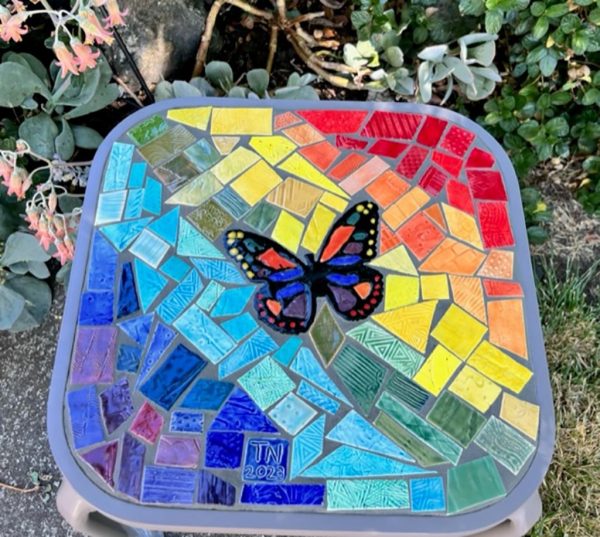 Trish Nugent colorful tile table with butterfly and rainbow design.