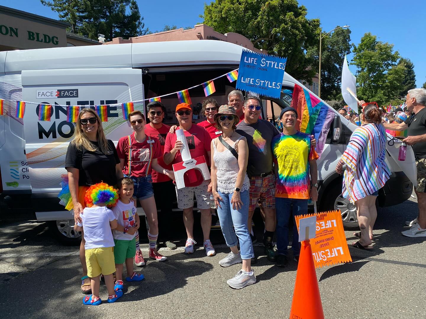 An image shows the staff of Face to Face in front of their mobile van. The group is smiling and dressed up in rainbow clothing for Sonoma County pride