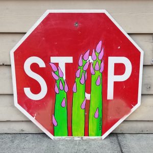 Reclaimed red stop sign with whimsical green and pink asparagus painted on the sign