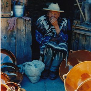 Steven Mayers' photo of a Mexican artist sitting in a doorway. Light and dark blues, shadows and orange foreground