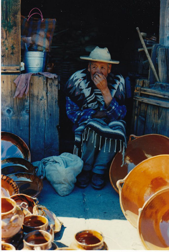 Steven Mayers' photo of a Mexican artist sitting in a doorway. Light and dark blues, shadows and orange foreground