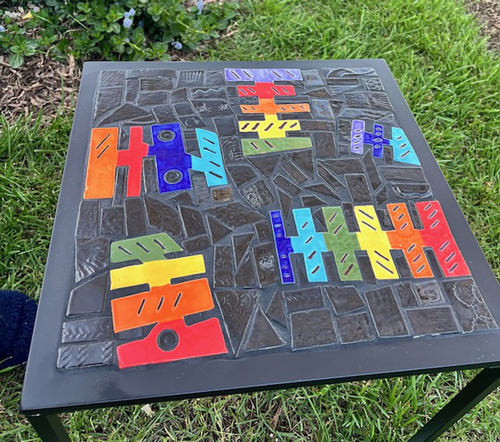 Trish Nugent outdoor table. Mosaic with artist-made tiles on a patio side table base. Rainbow colors