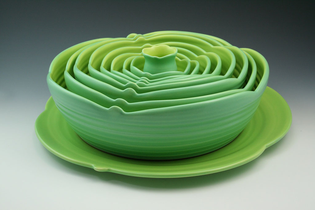 Marge Margulies 8 ceramic bowls in lime green nested onto a serving plate. Inspired by the gorgeous geometry of succulent plants, these ceramic functional centerpieces grace the table and add color to the room.