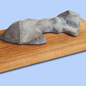 Susandra Spicer's cast stone female figure reclining on a wood base