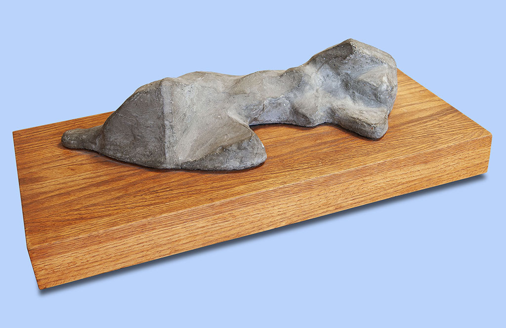 Susandra Spicer's cast stone female figure reclining on a wood base