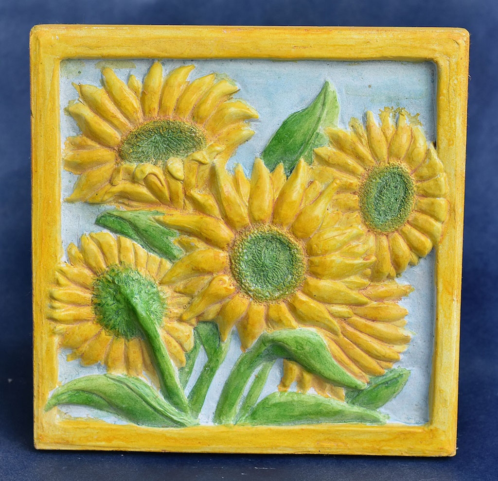 Ann Iverson's garden tile of cast concrete depicting yellow sunflowers, green leaves and stems