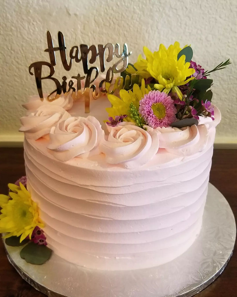 Consuelo Ardon's custom cake creation this image features a one-layer birthday cake with flowers on top.