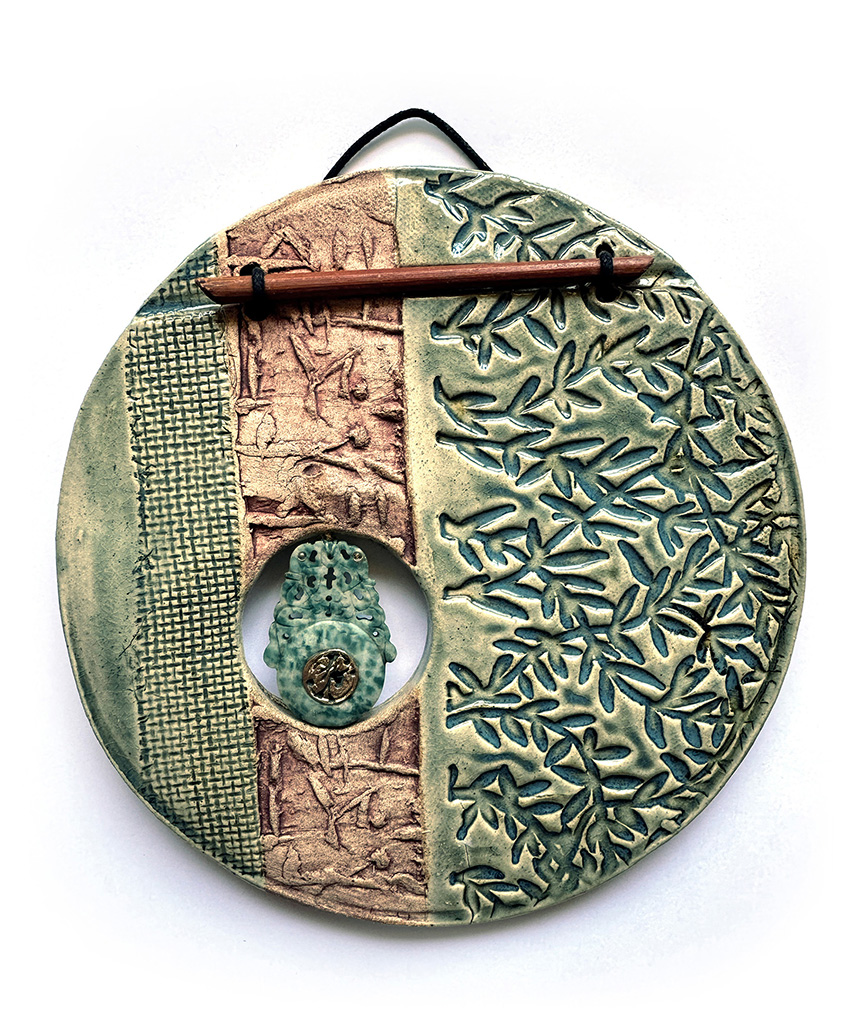 Maggie Bolt's circle clay wall plaque with carved jadeite in greens and browns