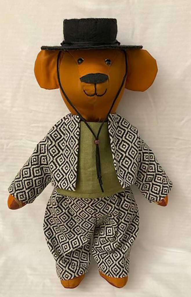 Mary Ryken's articulate bear made of drapery remnants. Dressed in green bolero outfit with black hat